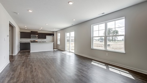great room with luxury vinyl flooring and kitchen with brown cabinets