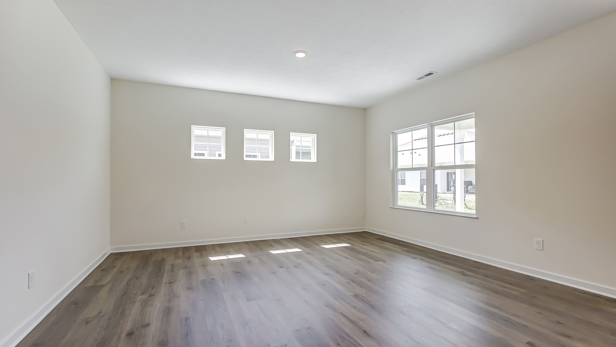 Bright living room with large windows and neutral walls.