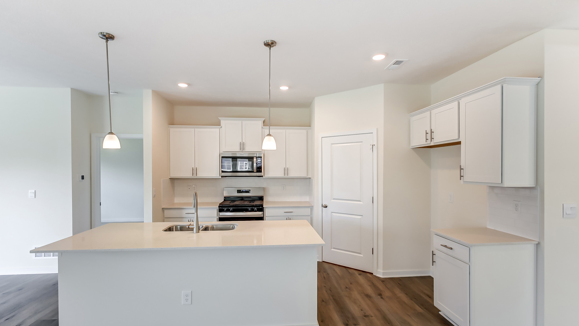 Kitchen featuring white cabinets, new stainless steel appliances, and white countertops.