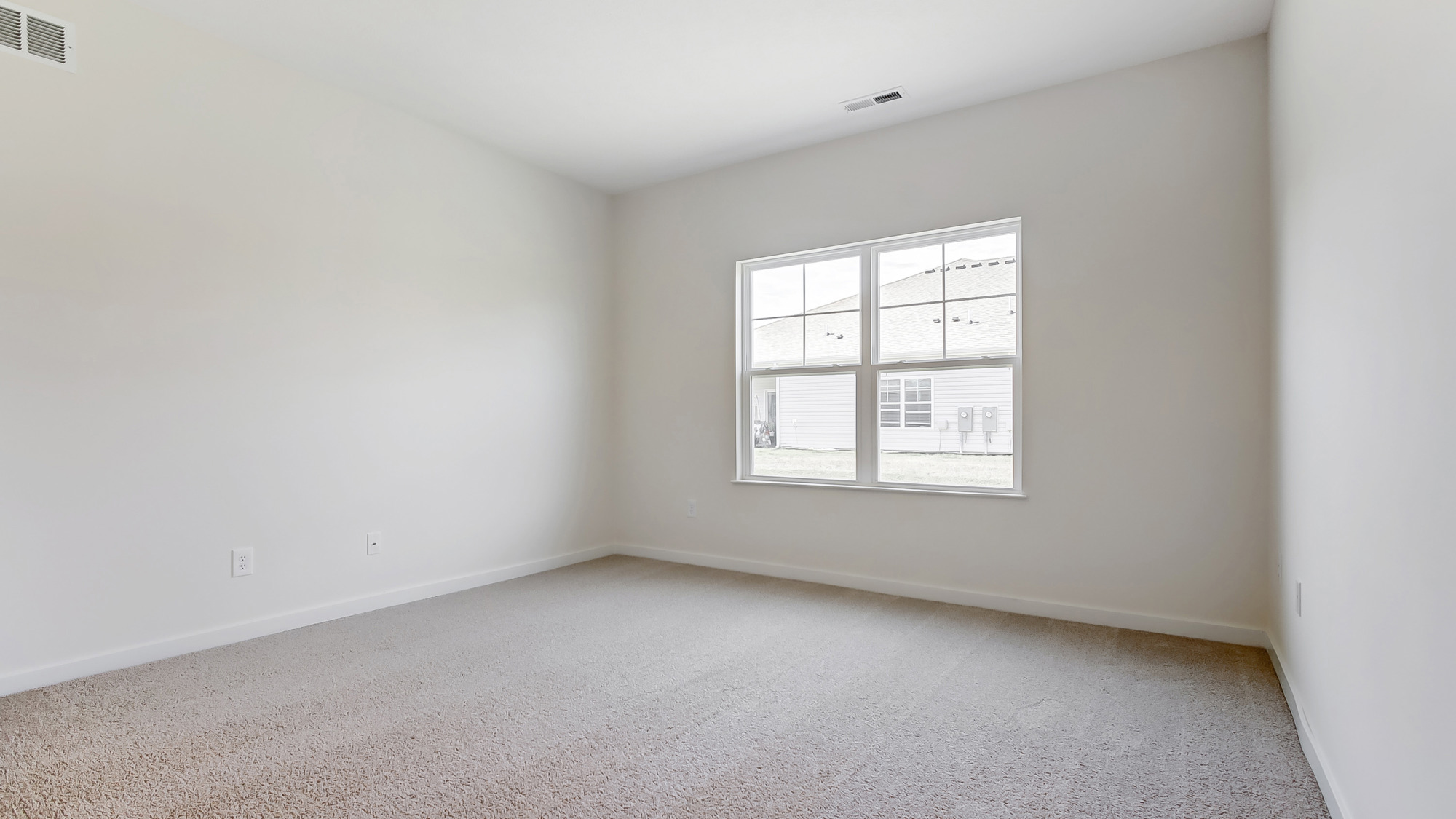 Primary bedroom with large windows and neutral walls.