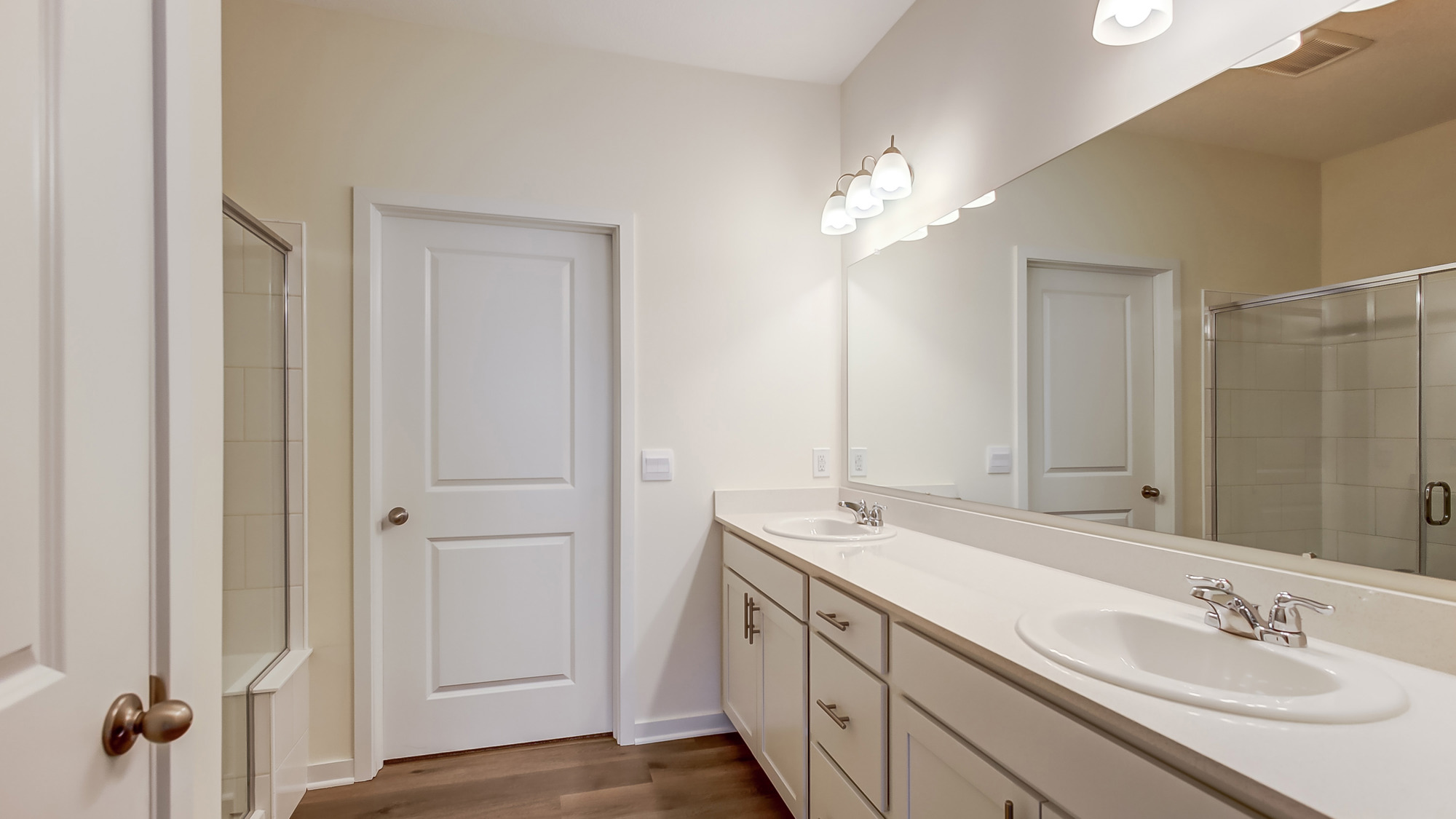 Bathroom with dual sinks and a walk in shower.