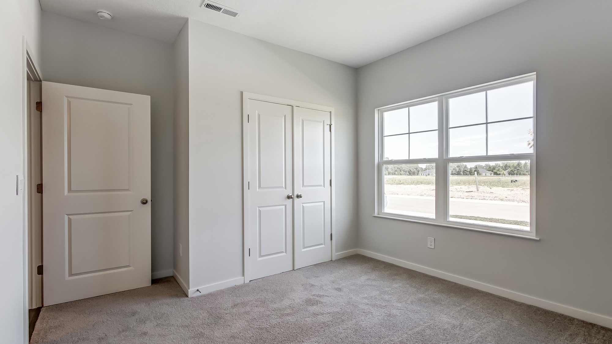 Bedroom with neutral walls, closet space, and natural lighting.