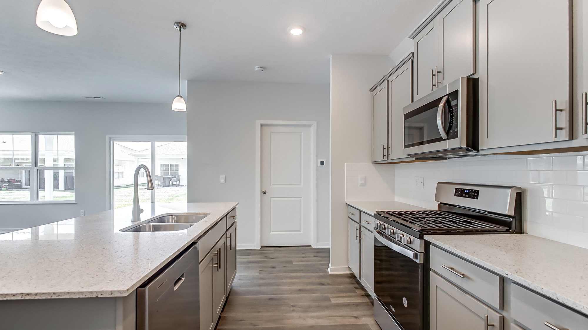 Kitchen showcasing new stainless steel appliances, cabinets, and countertops.