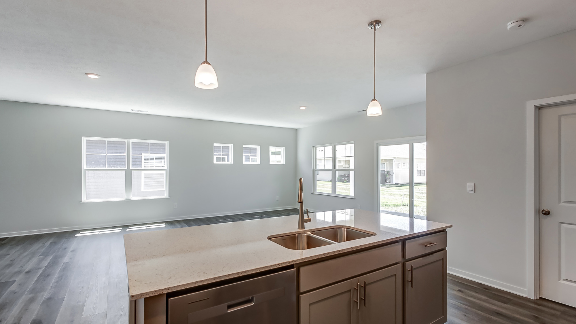 Open concept kitchen area connecting to living and dining space.