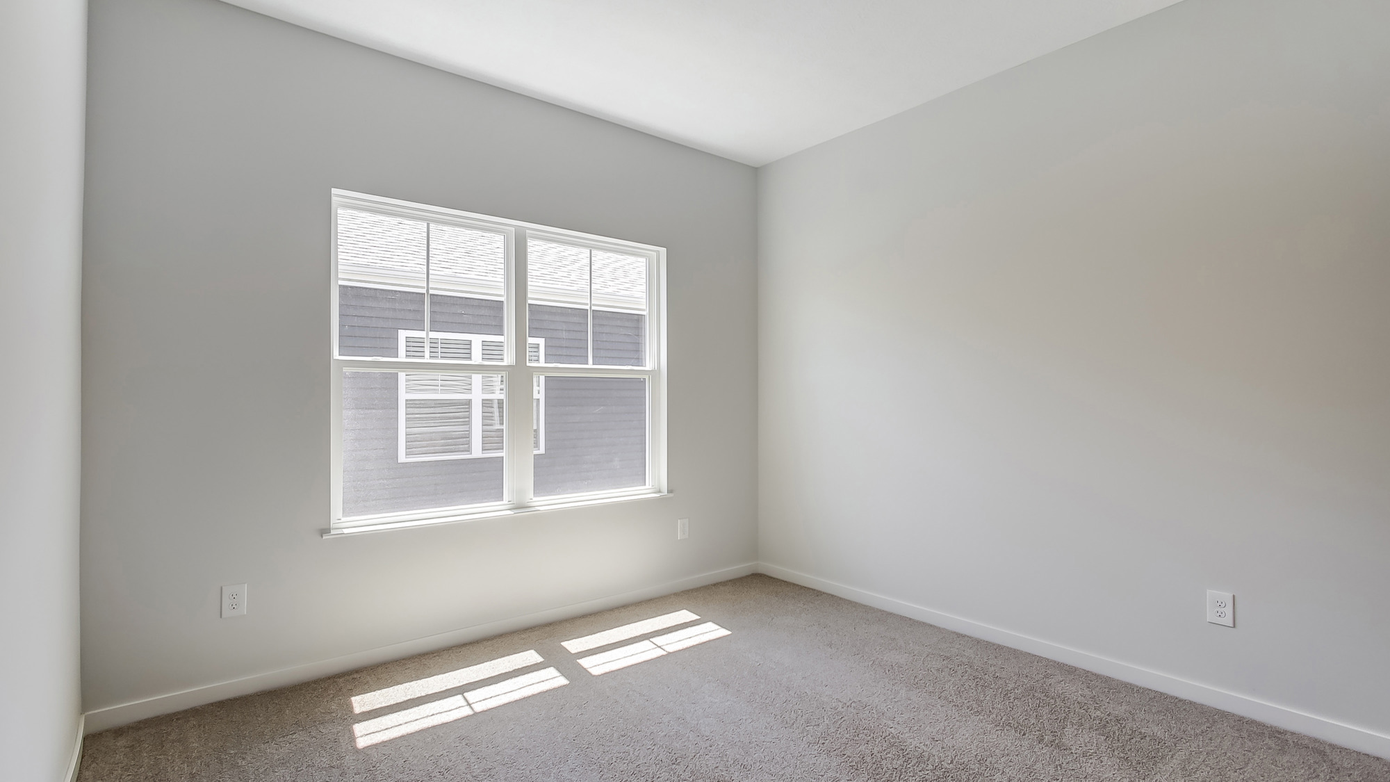 Bedroom with neutral walls, carpet, and a window.