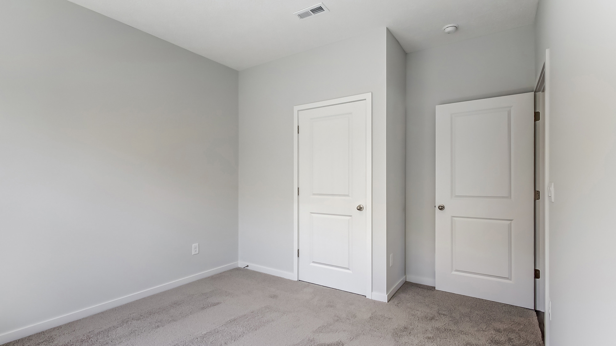 Bedroom with neutral walls, closet space, and natural lighting.