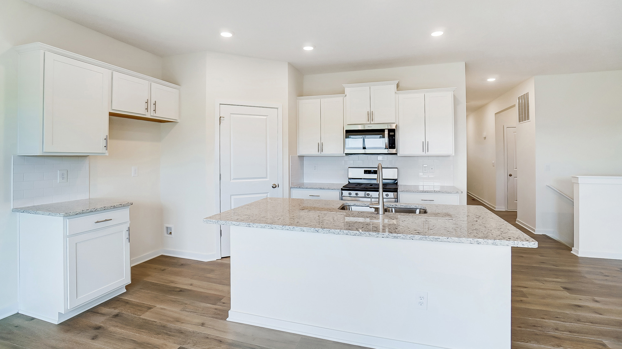Kitchen featuring brand new stainless steel appliances, cabinets, and a large island.