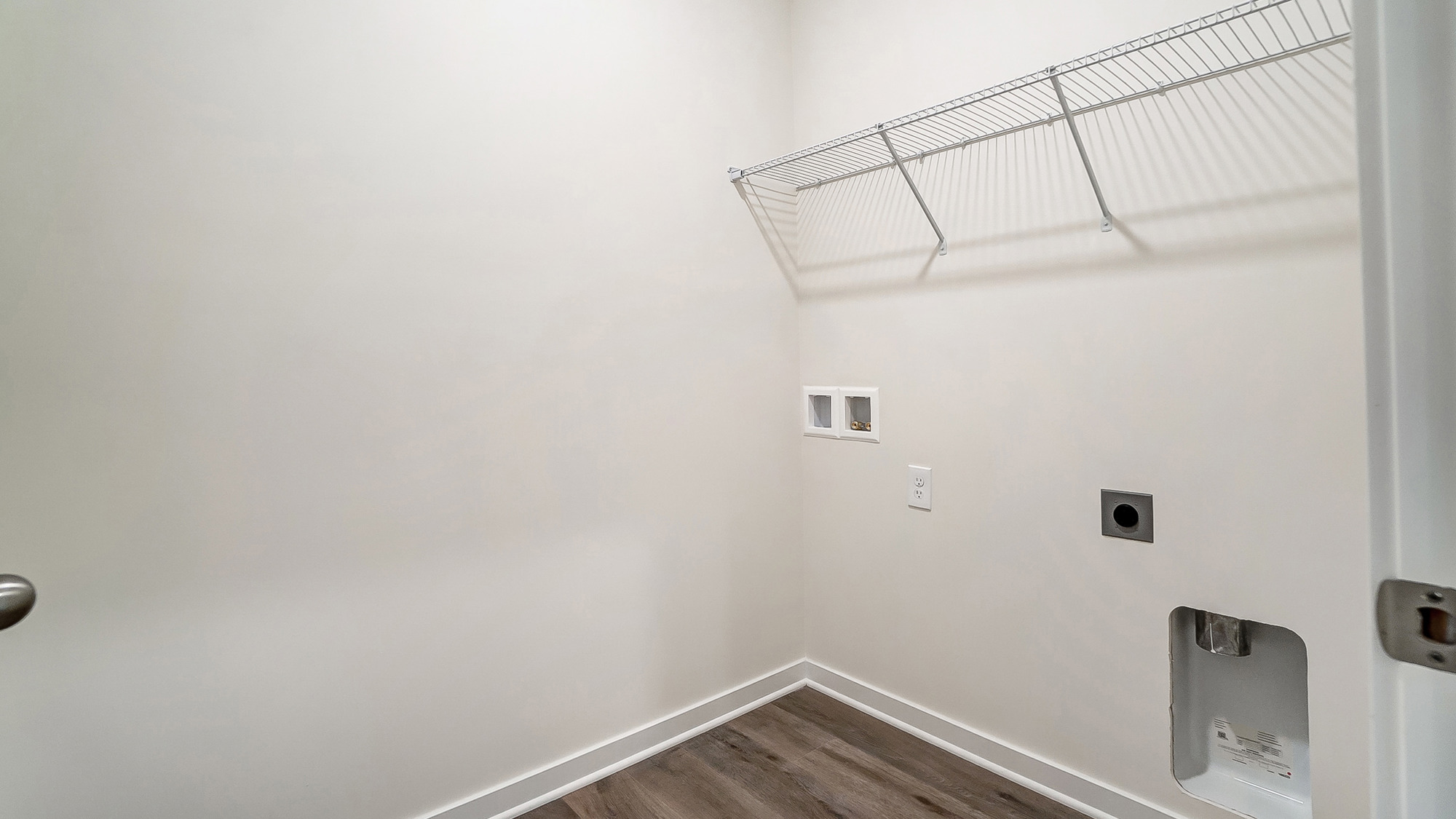 Laundry room with shelving above appliance hook ups.