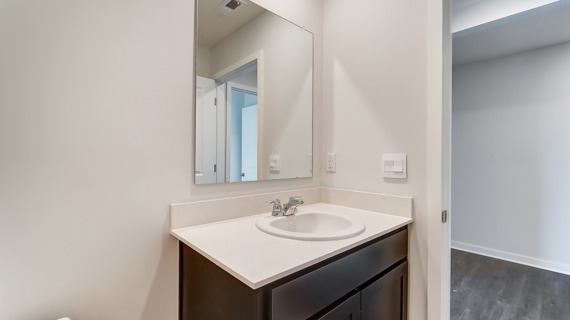 Bathroom with a sink and long mirror above.