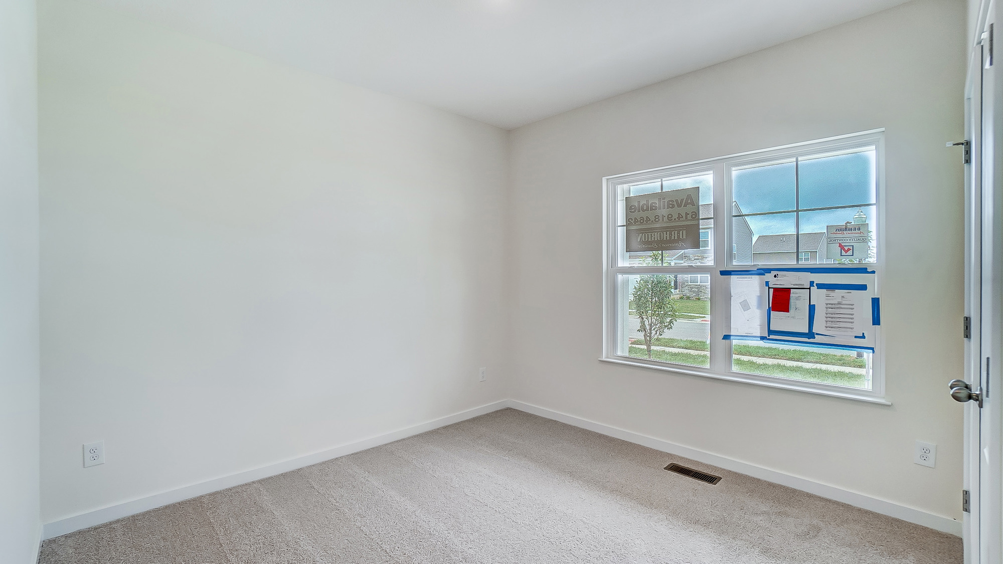 Bedroom with neutral walls, carpet, and a window.