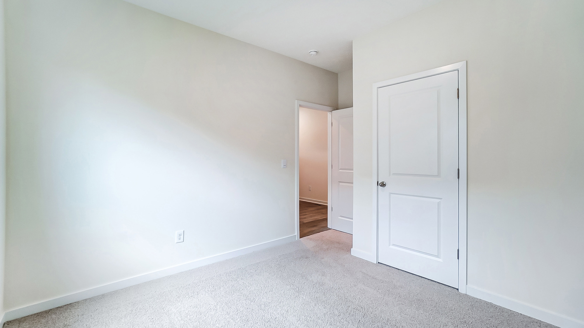 Bedroom with neutral walls, closet space, and natural lighting.