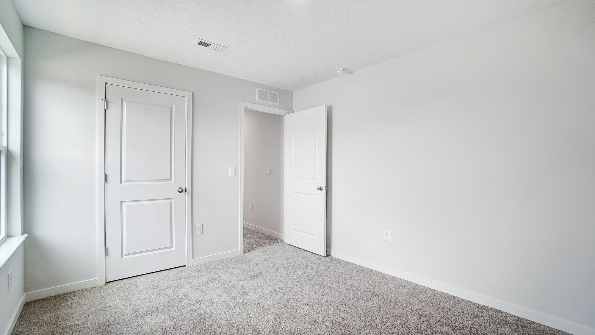 Bedroom with neutral walls, closet space, and natural lighting.