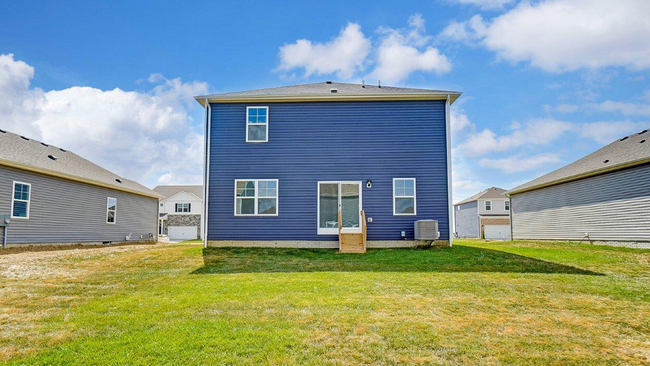 View of the rear of the home with open grassy area.
