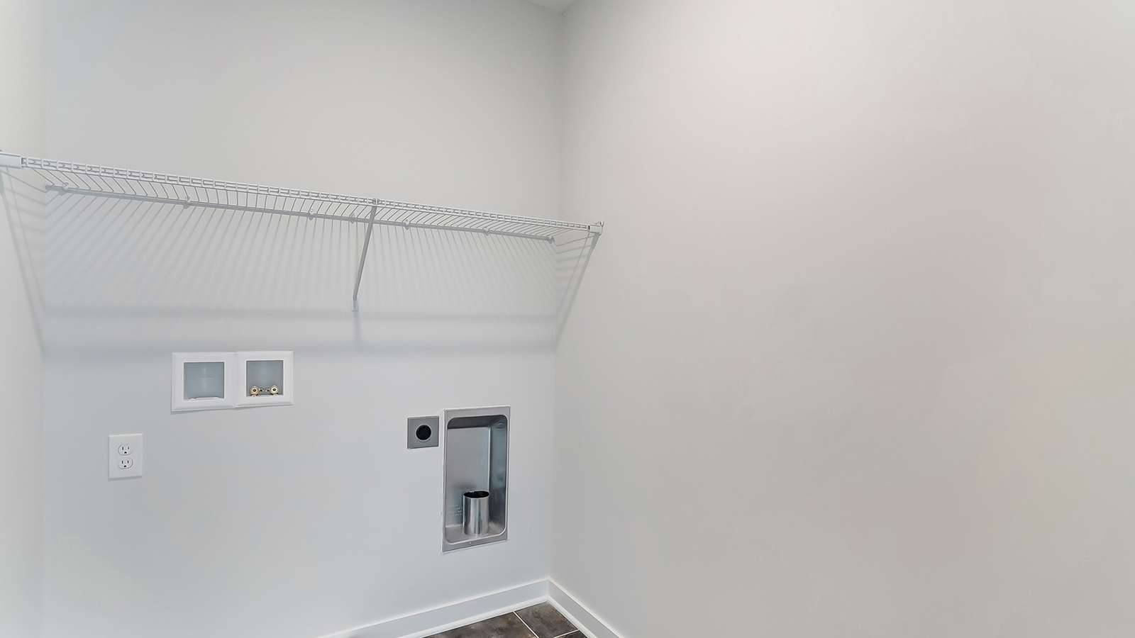 Laundry room with shelving above appliance hook ups.