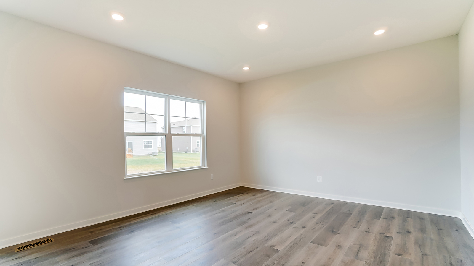 Bright living room with large windows and neutral walls.