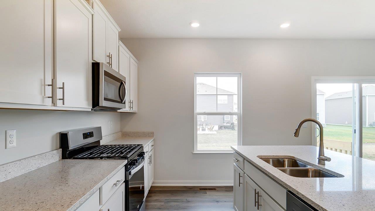 Kitchen showcasing new stainless steel appliances, cabinets, and countertops.