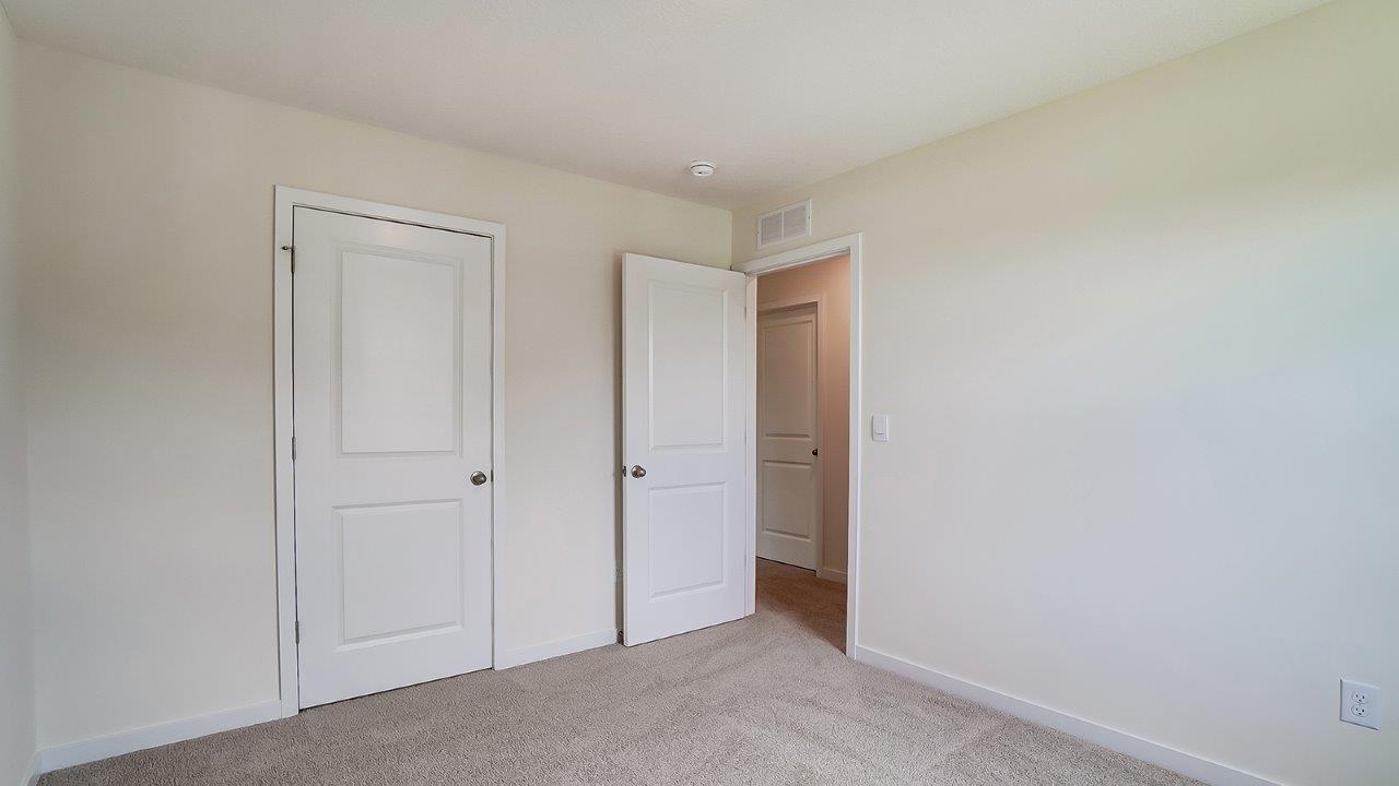 Bedroom with neutral walls, closet space, and natural lighting.