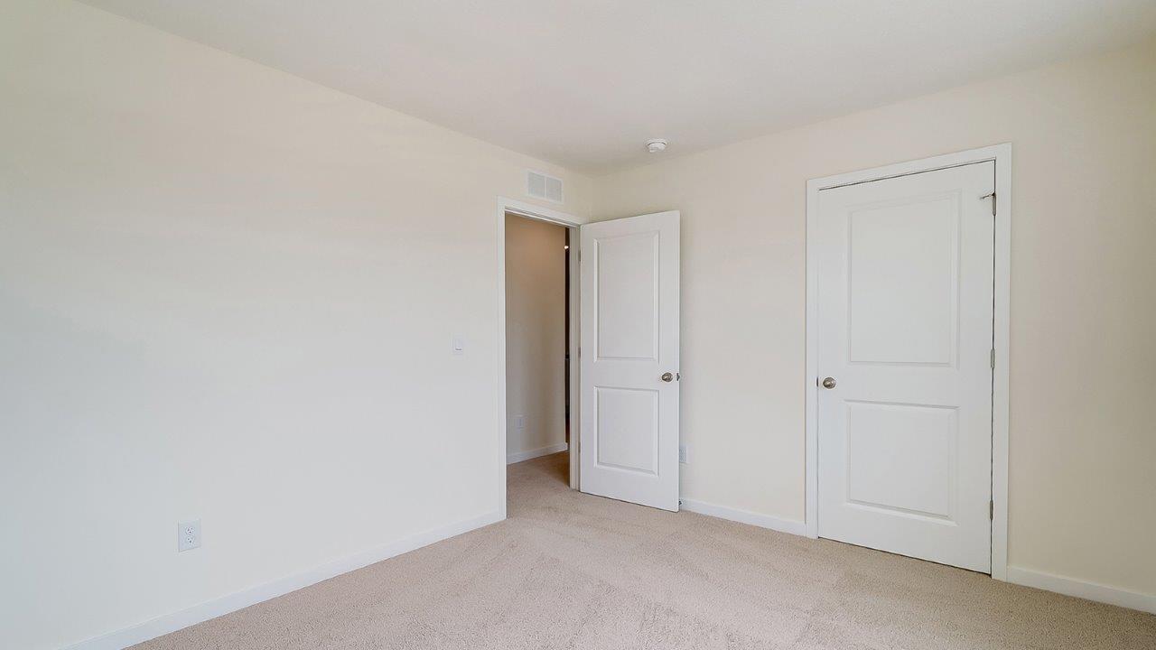Bedroom with neutral walls, closet space, and natural lighting.