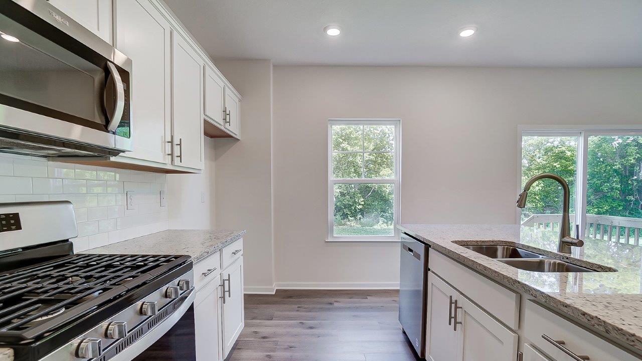 Kitchen featuring cabinets, new stainless steel appliances, and a large standing island.
