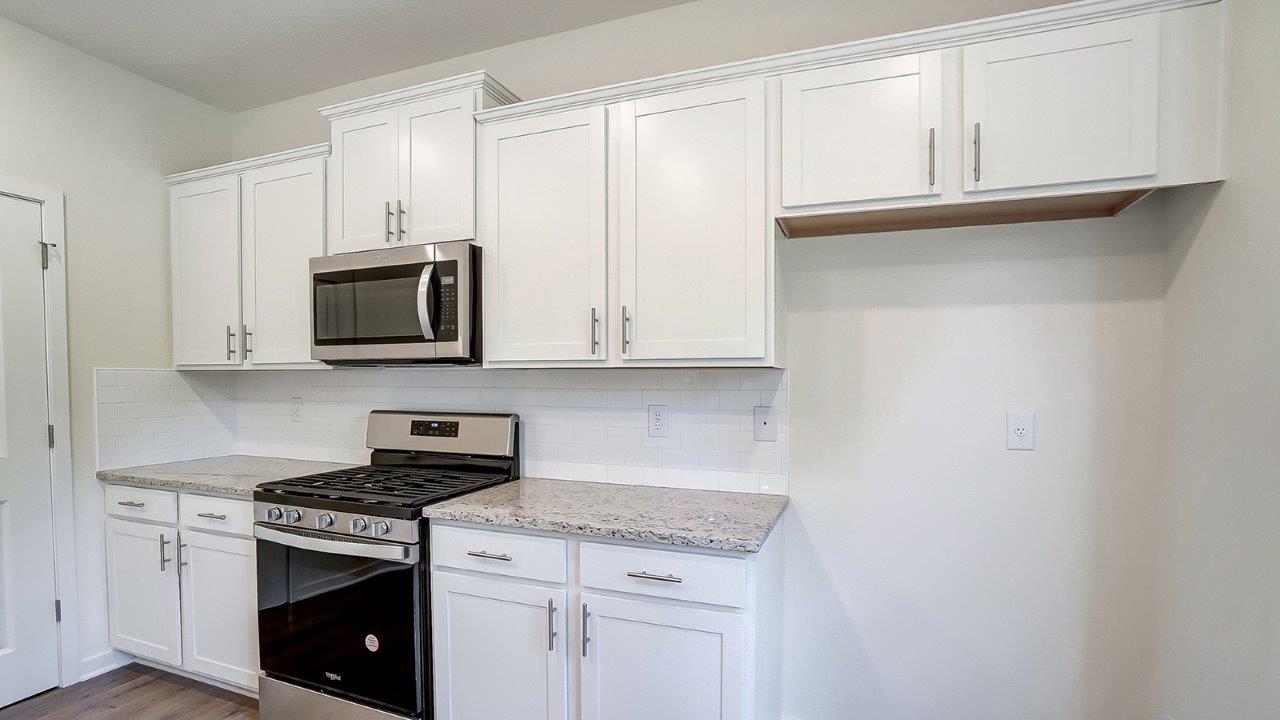 Kitchen showcasing new stainless steel appliances, cabinets, and countertops.