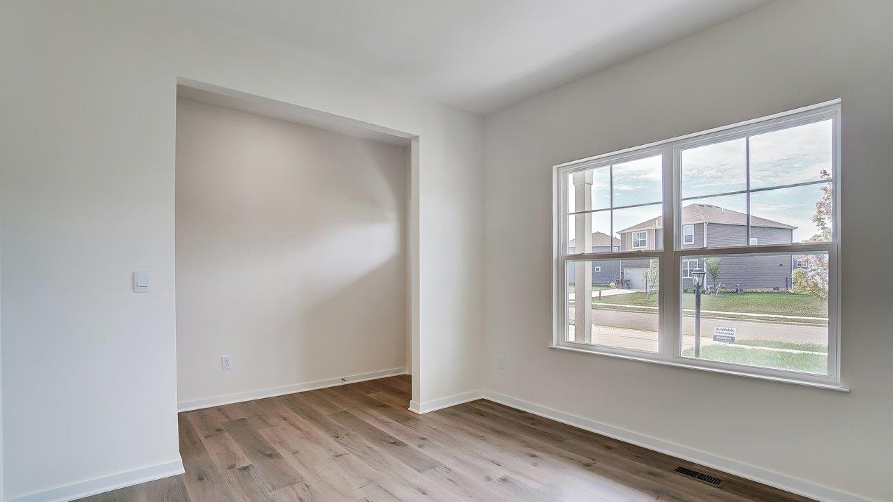 Dining area with large window and white walls off the entryway.