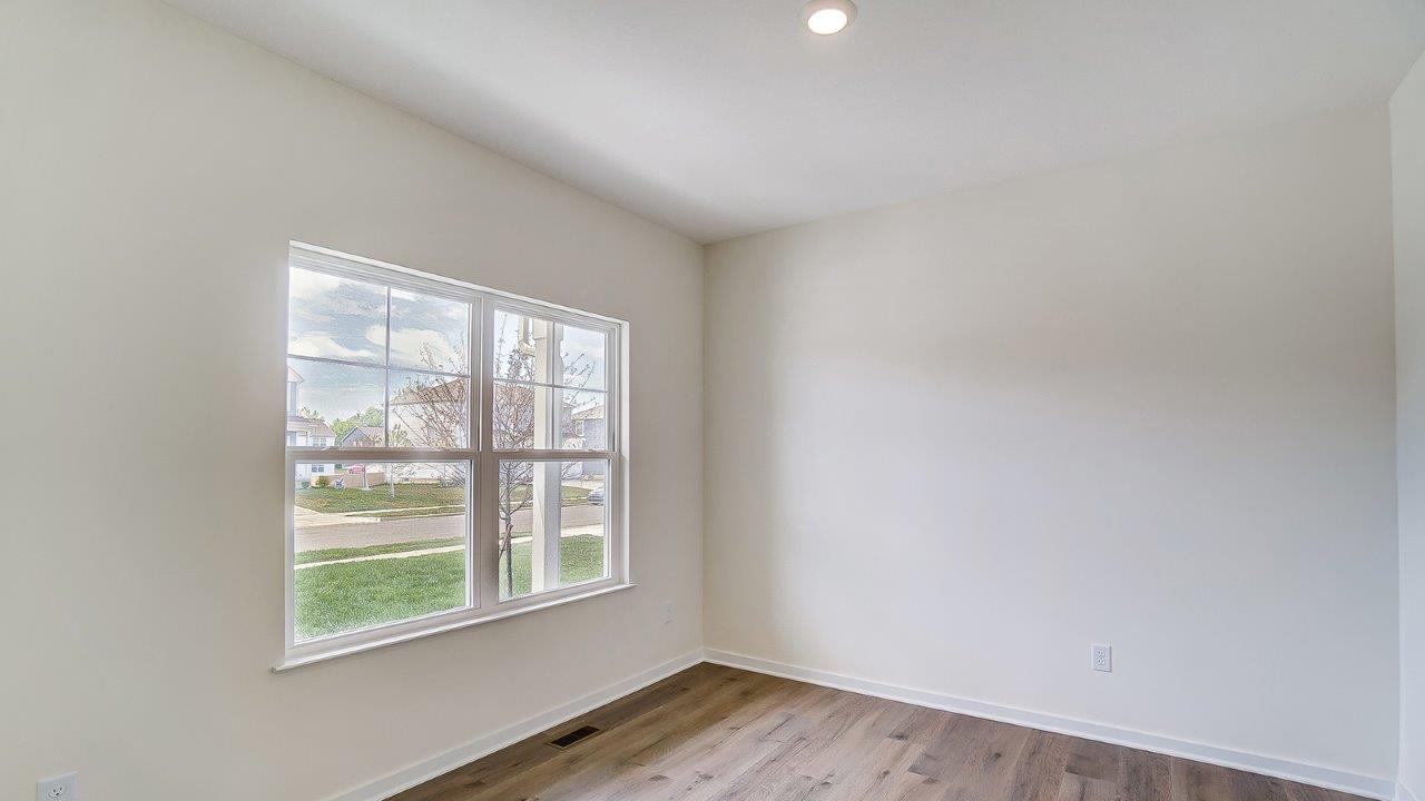 Dining area with large window and white walls.