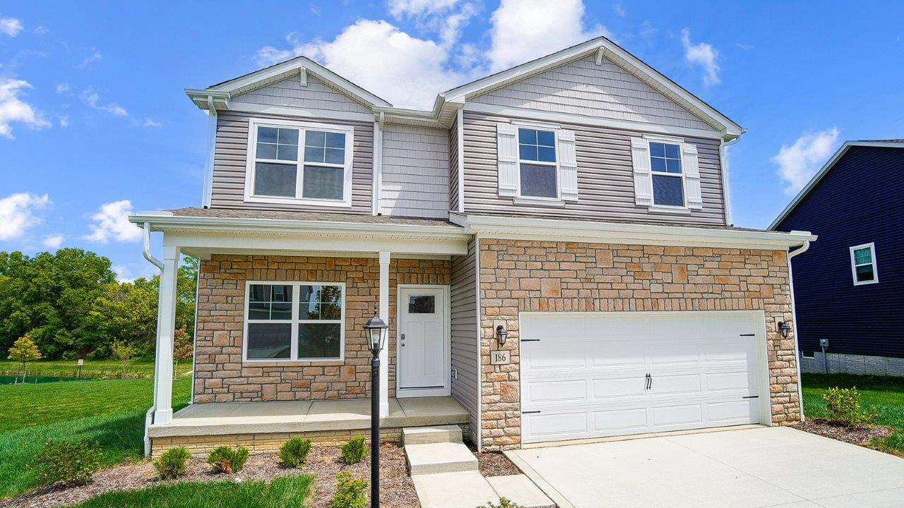 Modern suburban home with neutral exterior and stone accents and covered porch.