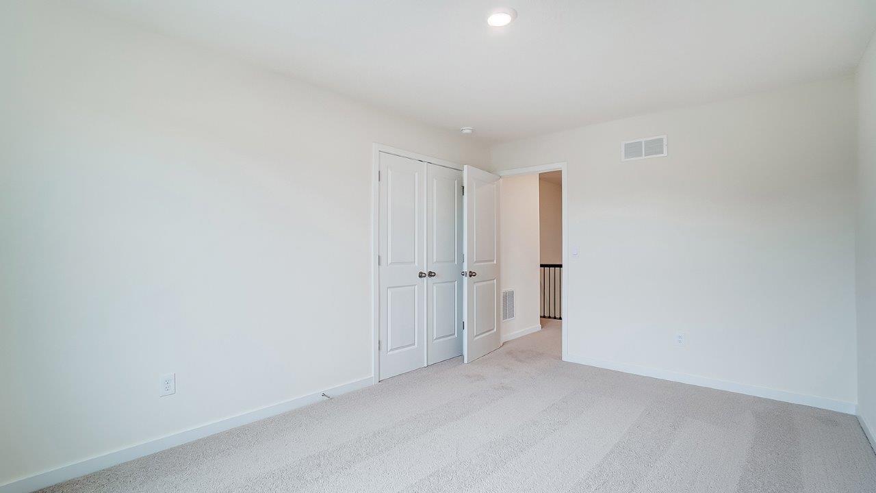Bedroom with neutral walls, closet space, and natural lighting.