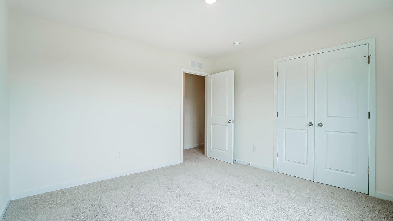 Bedroom with neutral walls, closet space, and natural lighting.
