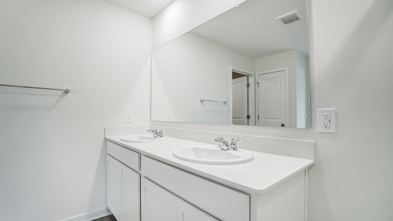 Bathroom with dual sinks and a wide mirror.