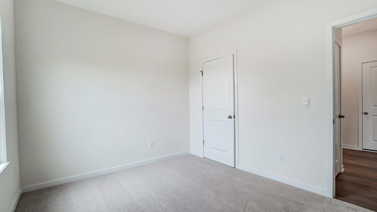 Bedroom with neutral walls, closet space, and natural lighting.