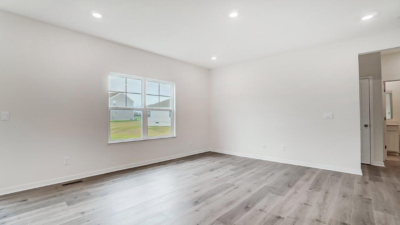 .Bright living room with large windows and neutral walls.