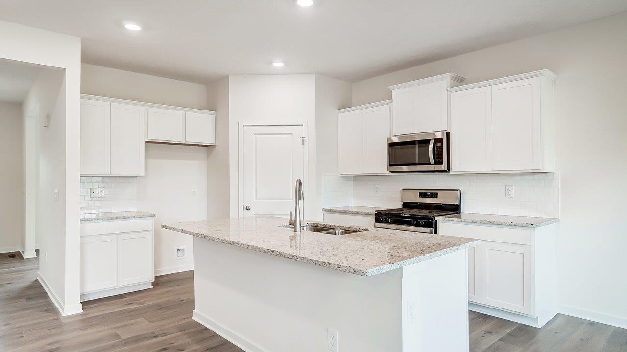 Kitchen featuring white cabinets, new stainless steel appliances, and white countertops.