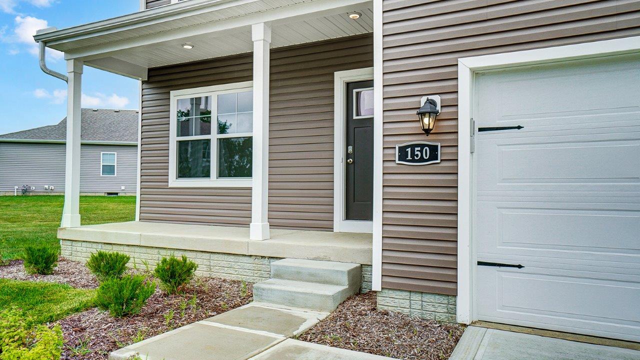 Close up of covered front porch and brown front door.