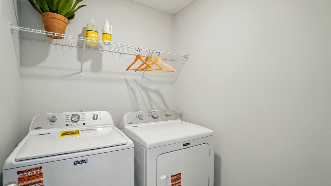 Laundry room with shelving above appliances.