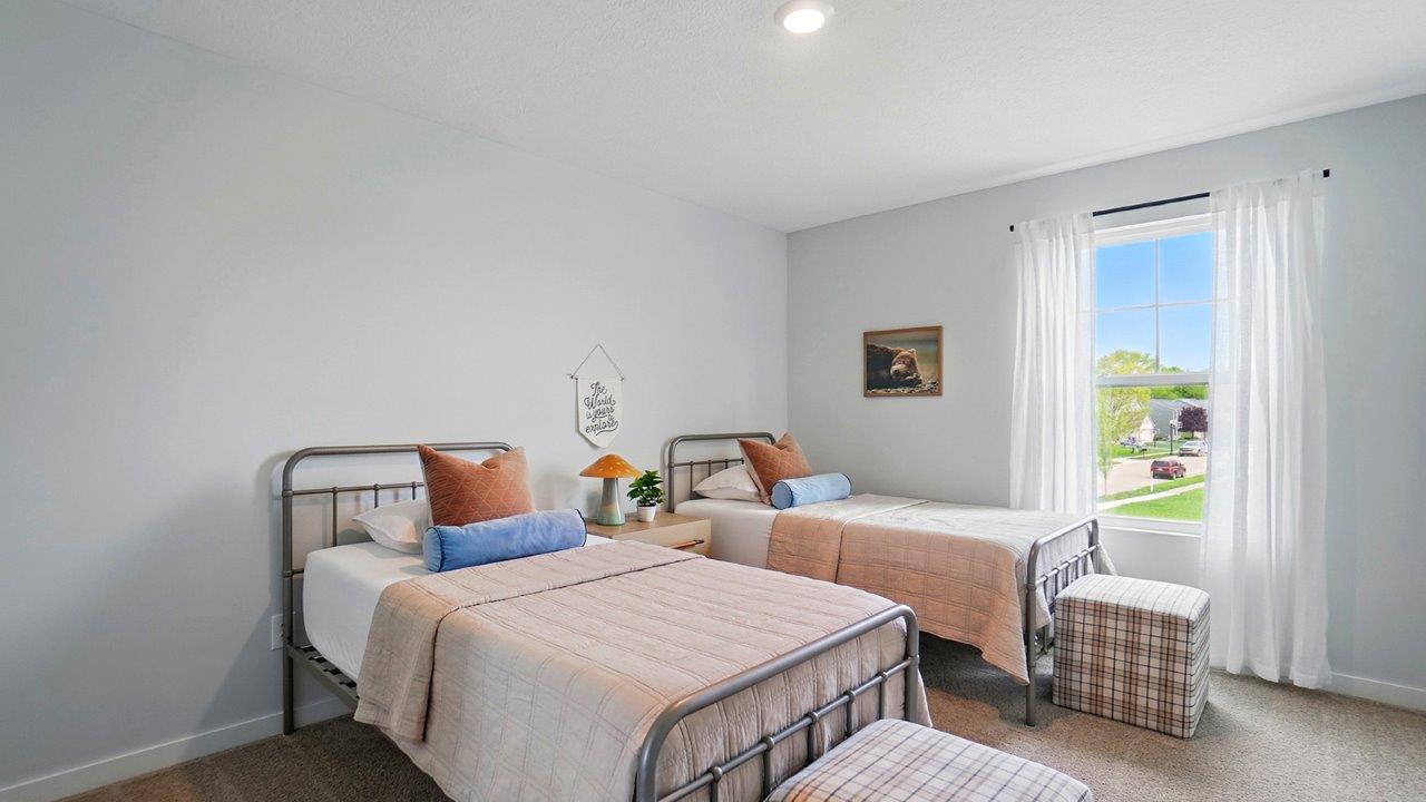Bedroom with neutral walls, furnishings, and a window.