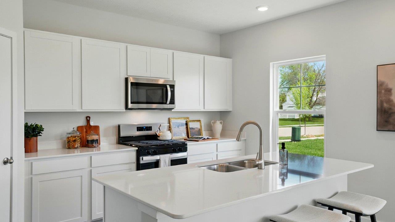 Kitchen featuring white cabinets, new stainless steel appliances, and white countertops.