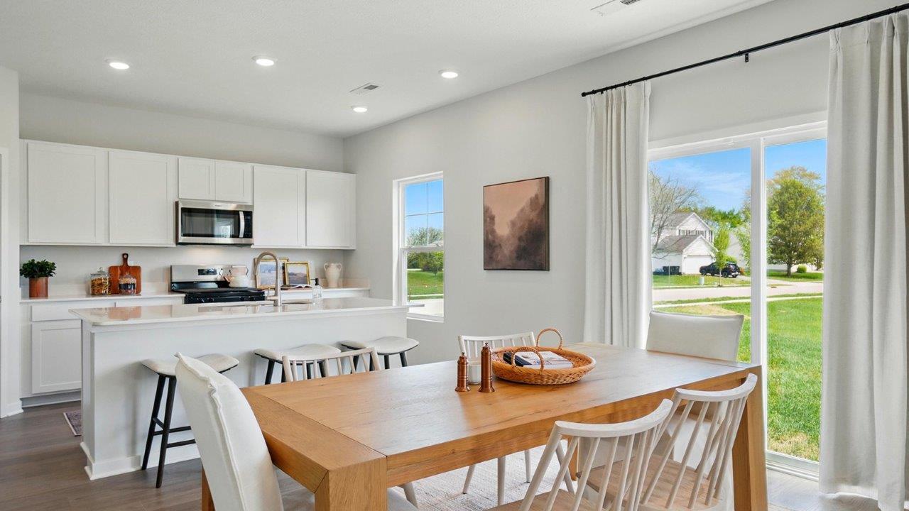Dining area with table, chairs, and natural lighting off the kitchen.