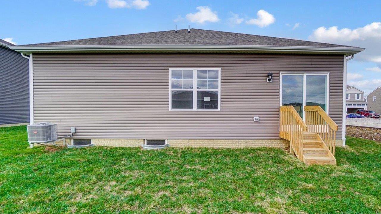 View of the rear of the home with open grassy area.
