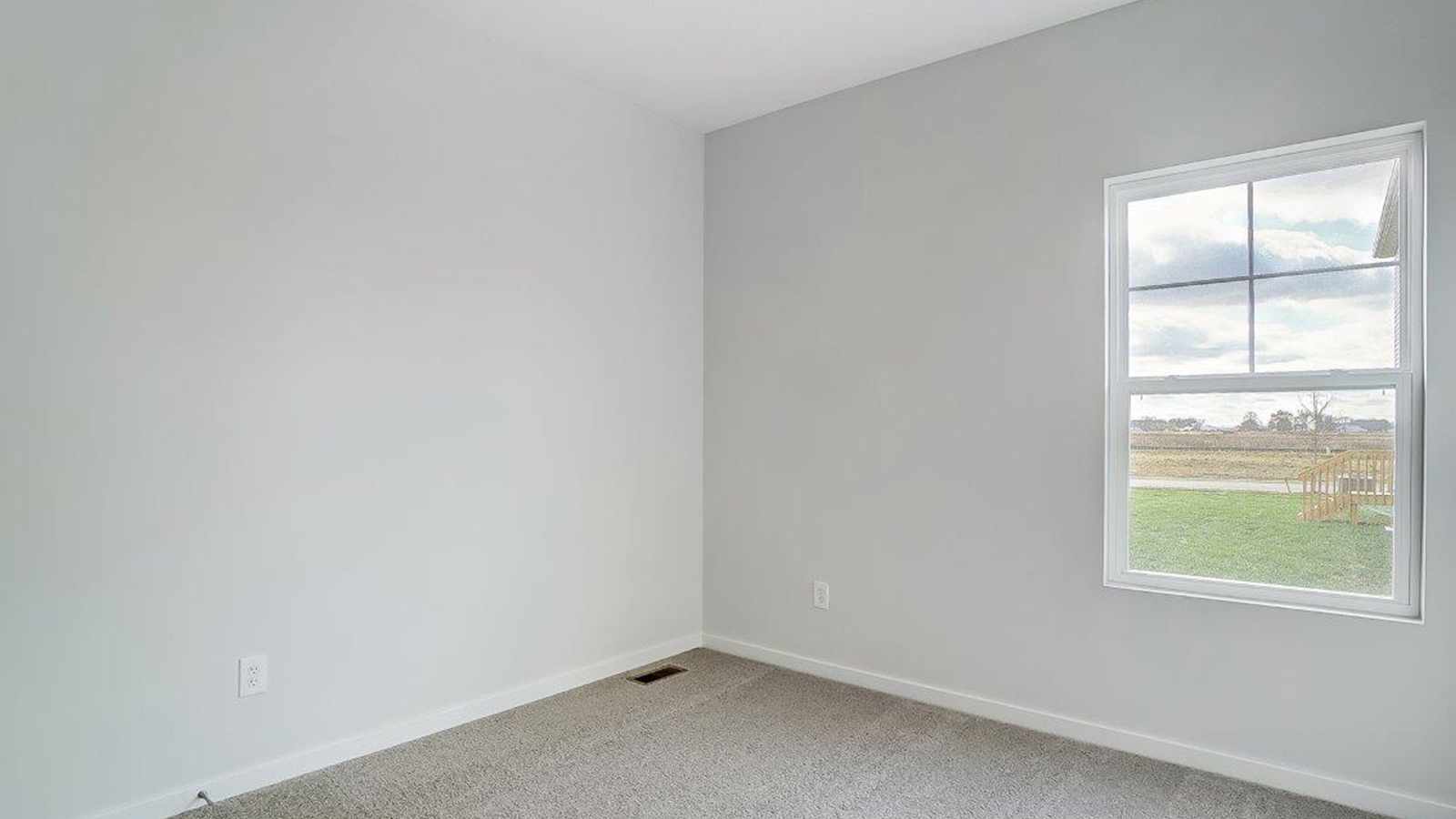 Bedroom with neutral walls, carpet, and a window.