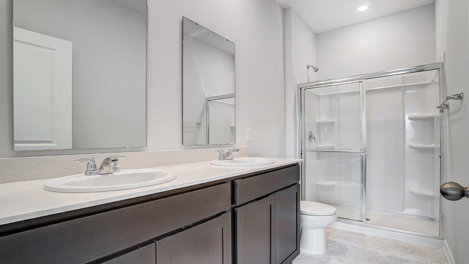 Bathroom with dual sinks and a walk in shower.