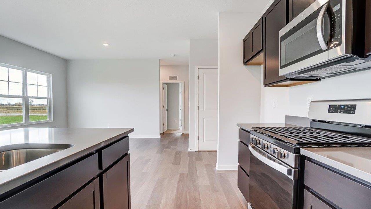 Kitchen showcasing new stainless steel appliances, cabinets, and countertops.