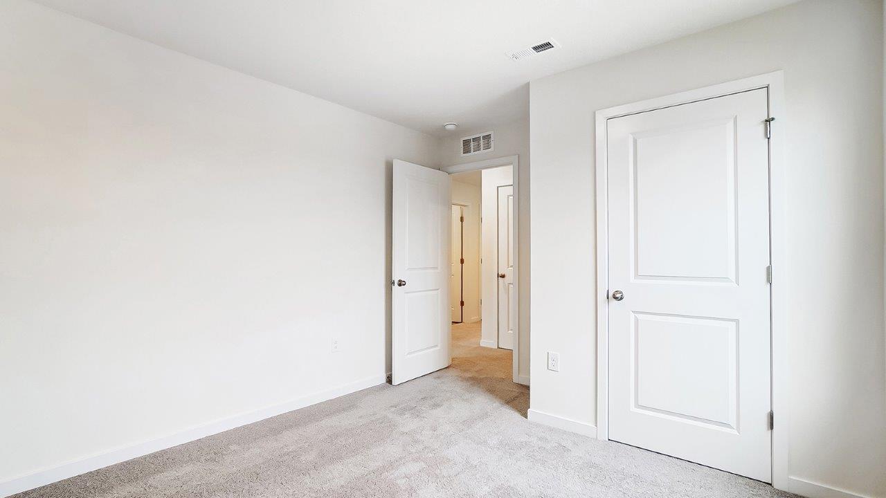 Bedroom with neutral walls, closet space, and natural lighting.
