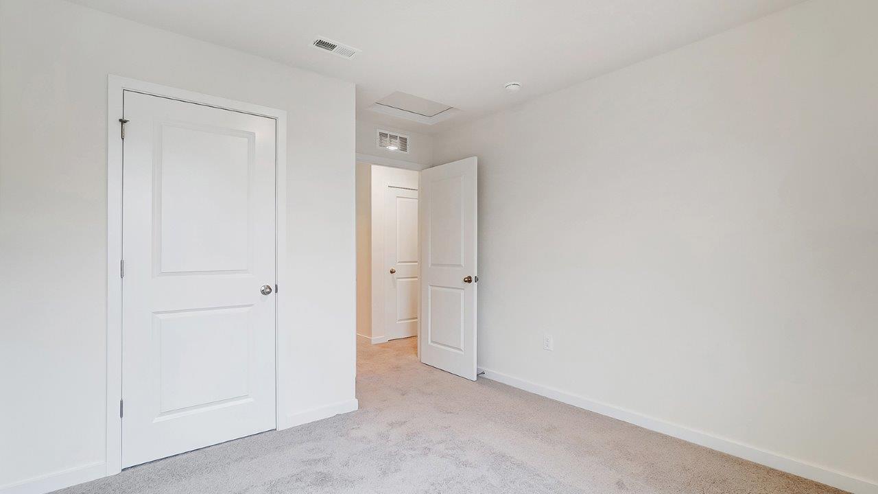 Bedroom with neutral walls, closet space, and natural lighting.