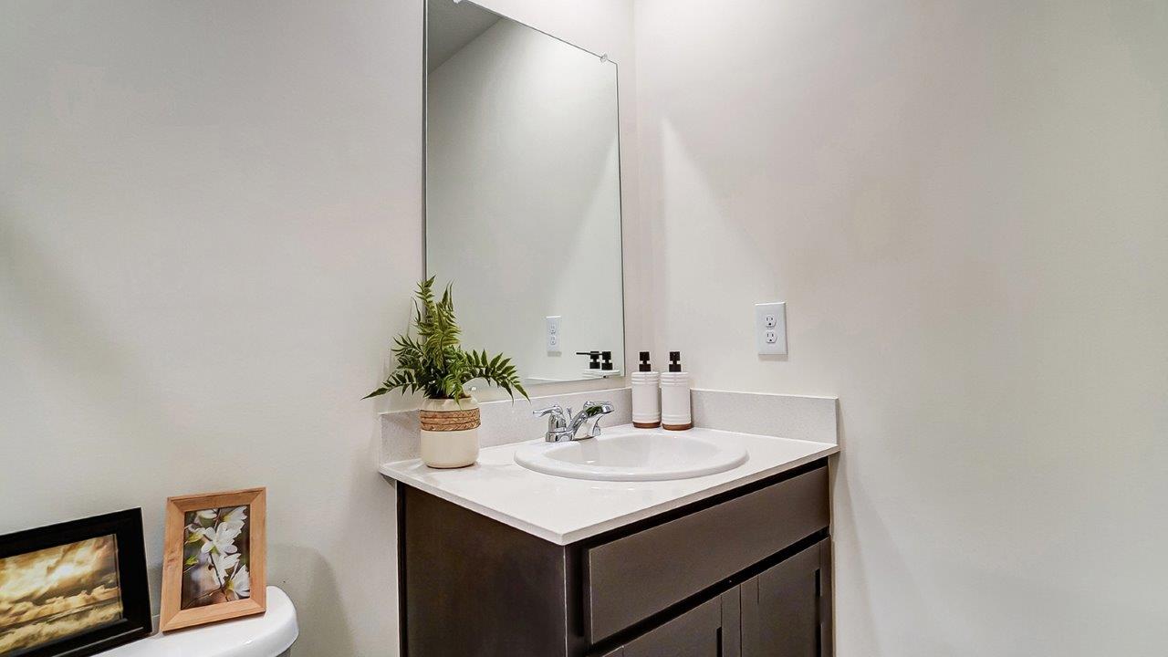Bathroom with a sink and long mirror above.