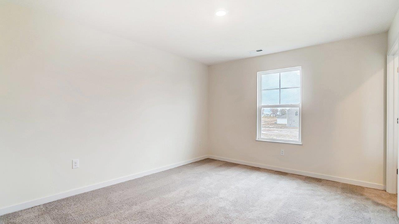 Primary bedroom with large windows and neutral walls.