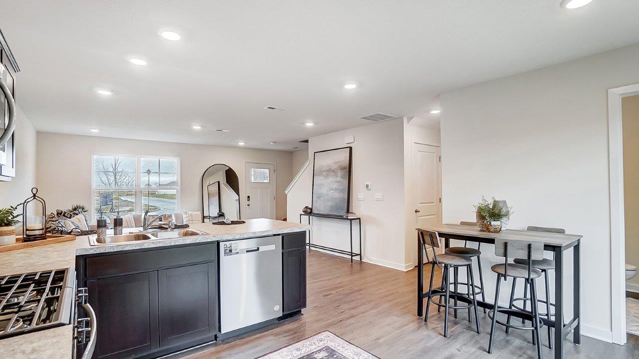 Kitchen featuring dark cabinets, new stainless steel appliances, and textured countertops.