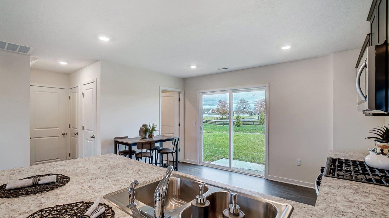 Kitchen featuring cabinets, new stainless steel appliances, and large countertops connecting to dining area and sliding door,