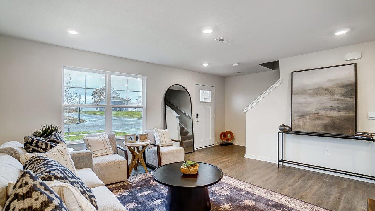 Living area with simple furnishings and an area rug.