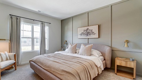 primary bedroom with bed, nightstands and accent chair
